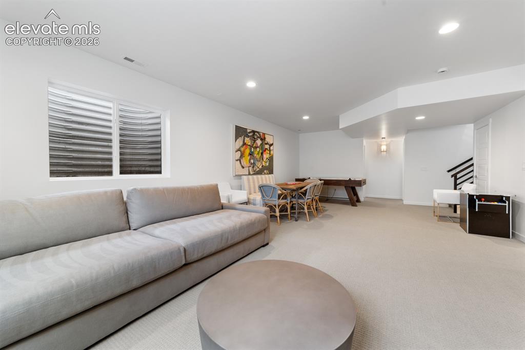 Image 35 of 38: Spacious recreation room featuring light-colored carpeting, a recessed wind