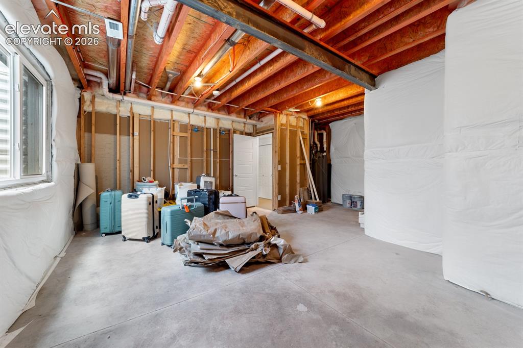 Image 38 of 38: Unfinished basement featuring exposed wood ceiling joists, concrete floorin