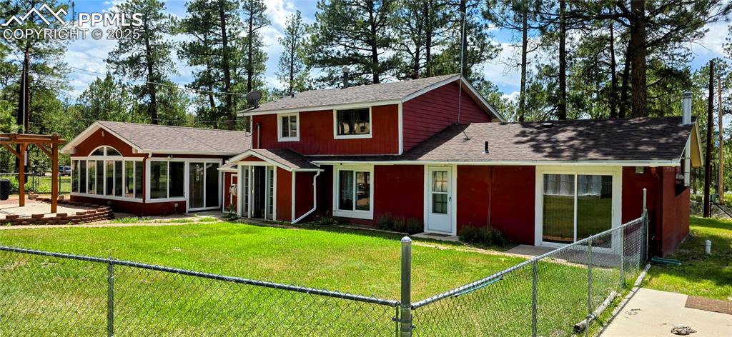 Image 2 of 48: Traditional-style home featuring a shingled roof, a fenced backyard, and a 
