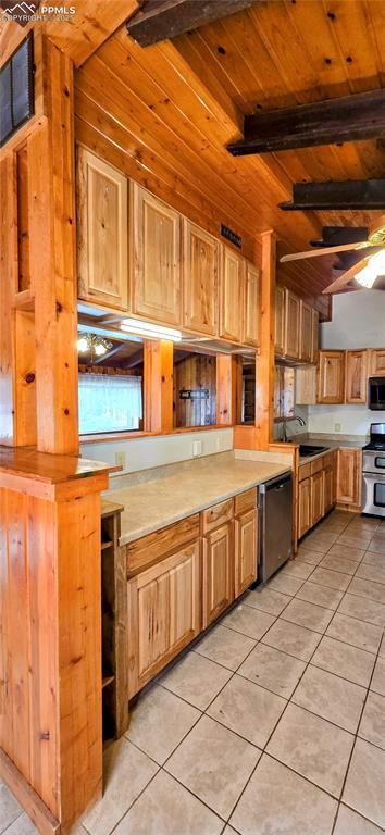 Image 29 of 48: Kitchen featuring light tile patterned floors, light countertops, stainless