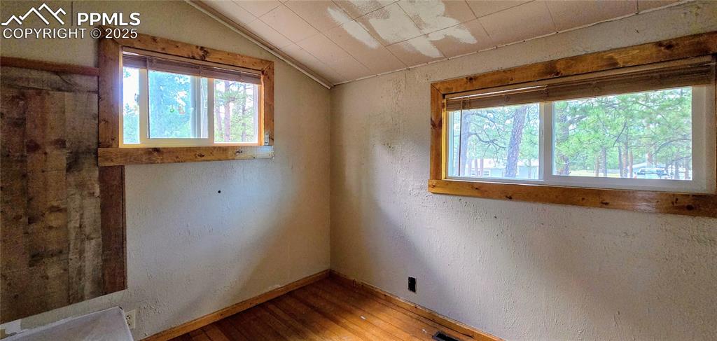 Image 41 of 48: Spare room featuring a textured wall, hardwood / wood-style flooring, and l