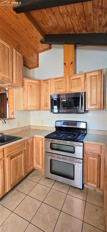 Image 45 of 48: Kitchen featuring appliances with stainless steel finishes, light tile patt