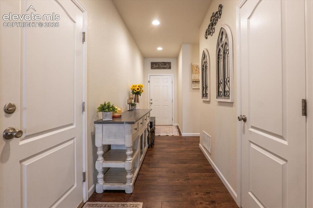 Image 9 of 50: Long hallway with main level bedroom around the corner