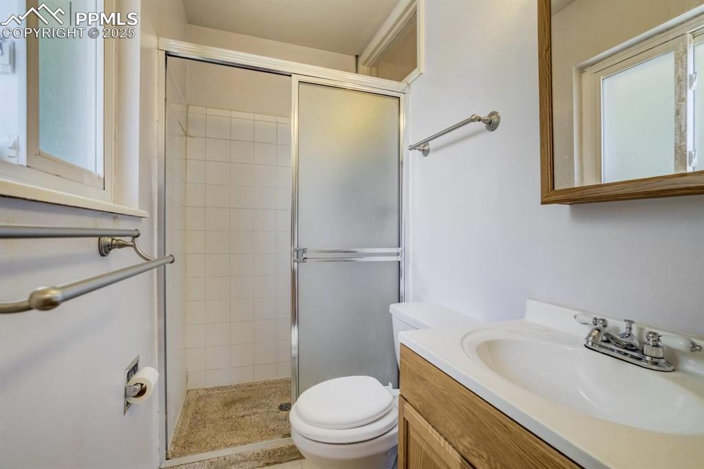 Image 15 of 37: Bathroom featuring a shower stall and vanity