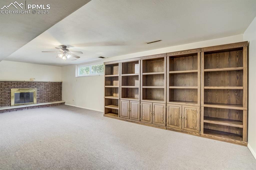 Image 19 of 37: Unfurnished living room featuring carpet floors, a brick fireplace, and a c