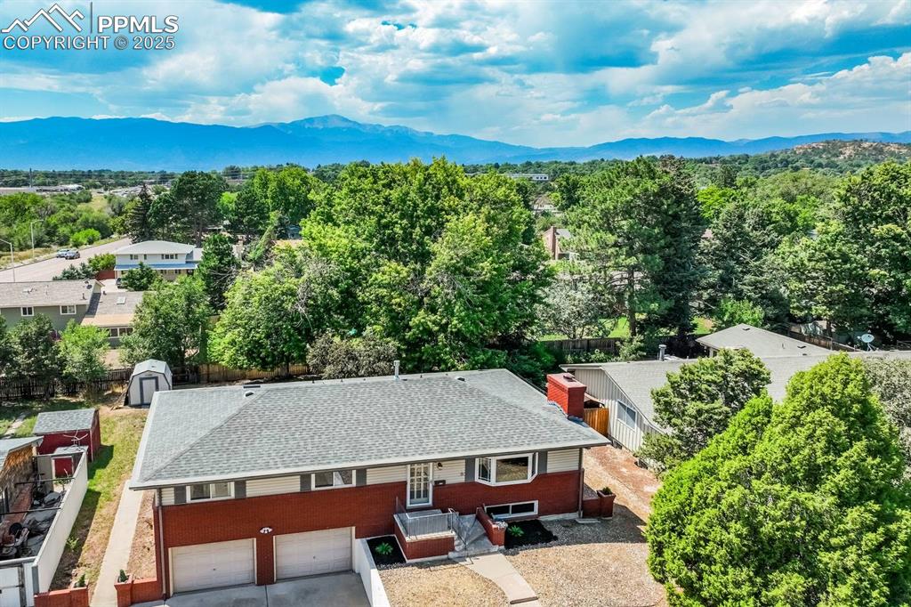 Image 2 of 37: View of subject property featuring a mountain backdrop and a heavily wooded