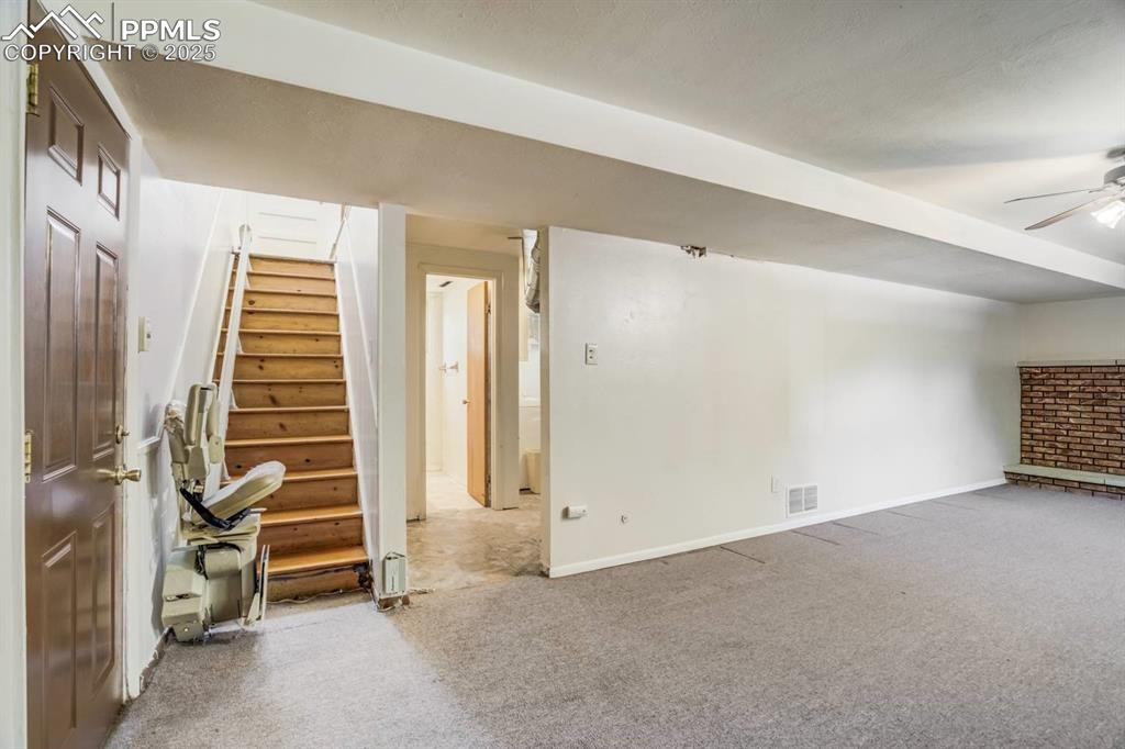 Image 20 of 37: Finished basement featuring stairway, carpet flooring, and a ceiling fan