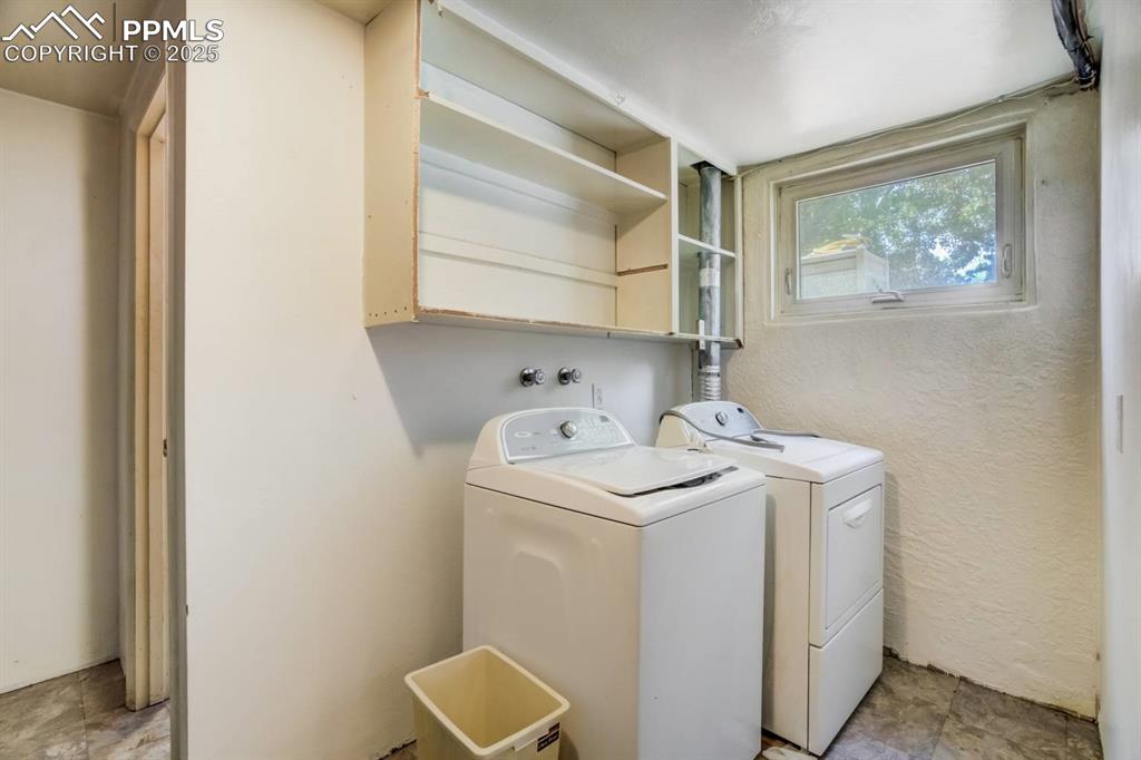 Image 22 of 37: Washroom with washing machine and clothes dryer and a textured wall