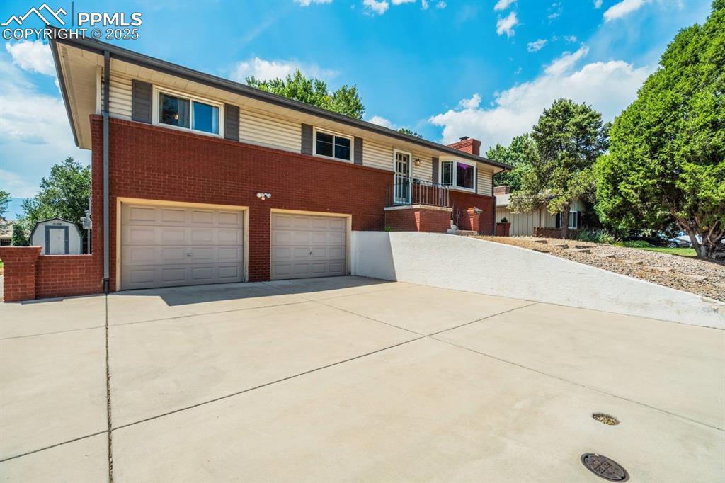 Image 3 of 37: Ranch-style house featuring brick siding, driveway, an attached garage, and