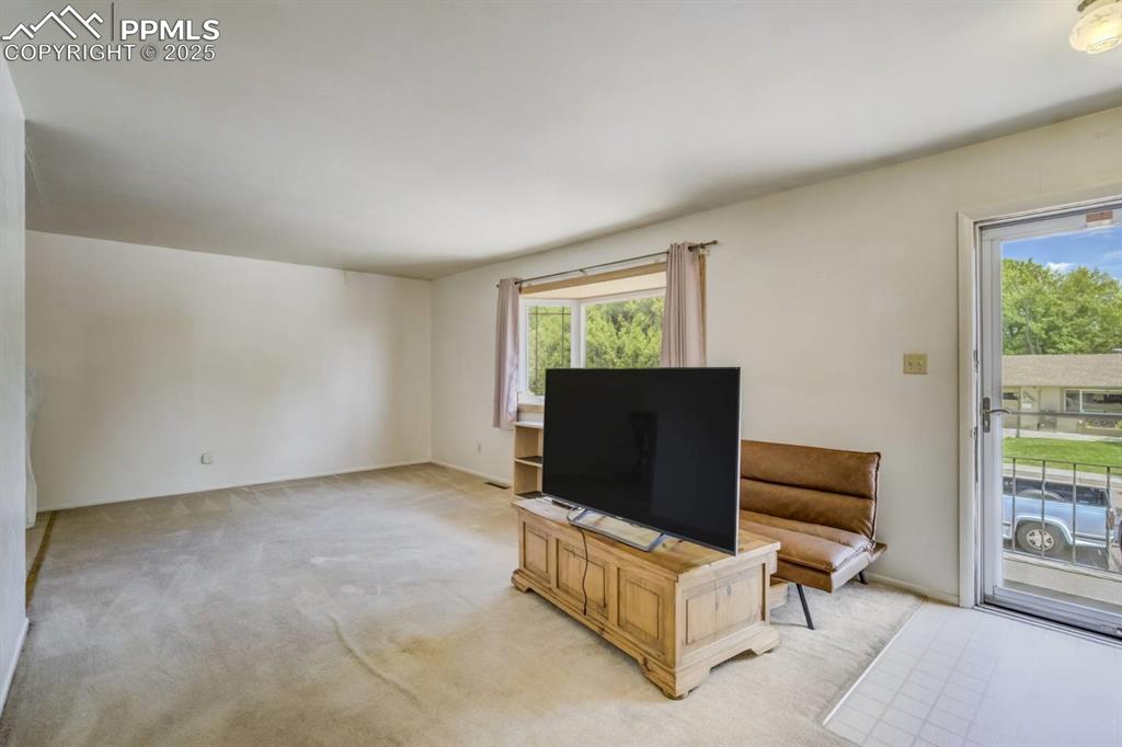 Image 5 of 37: Living area with light colored carpet