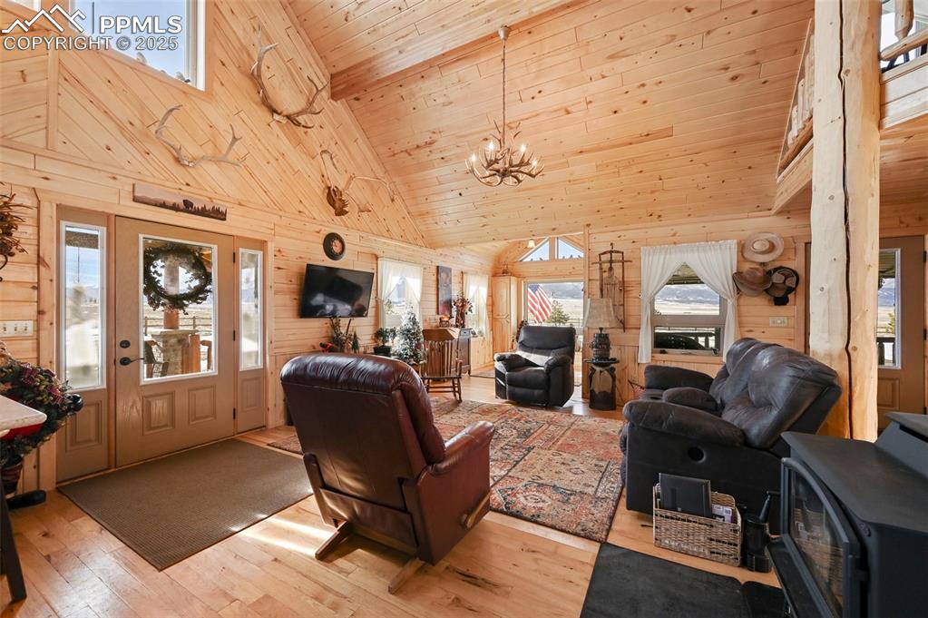 Image 19 of 50: Living room featuring high vaulted ceiling, wooden ceiling, a chandelier, l