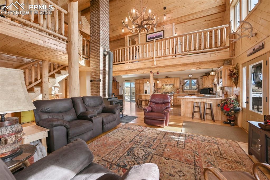Image 21 of 50: Living area featuring a notable chandelier, wooden ceiling, stairway, woode