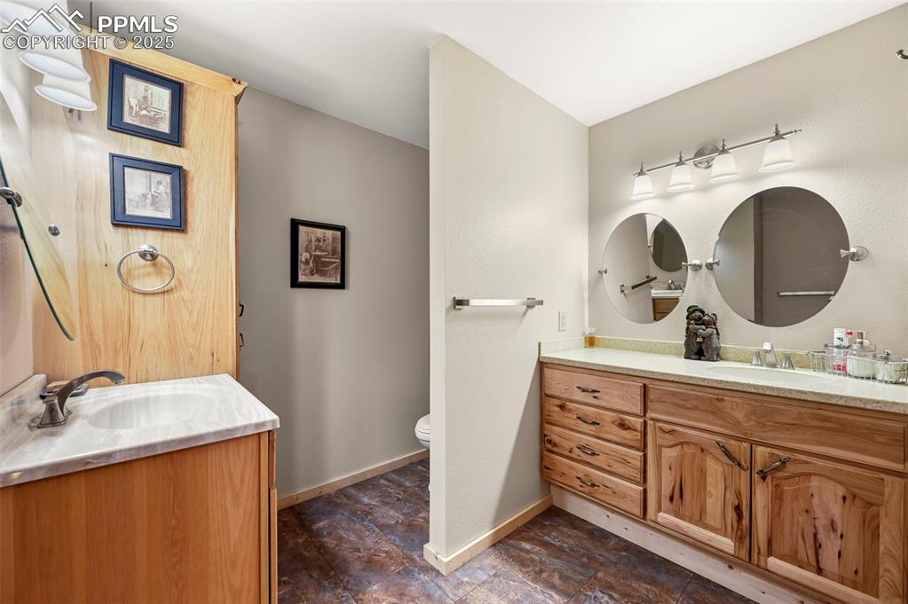 Image 29 of 50: Bathroom featuring baseboards, toilet, and vanity