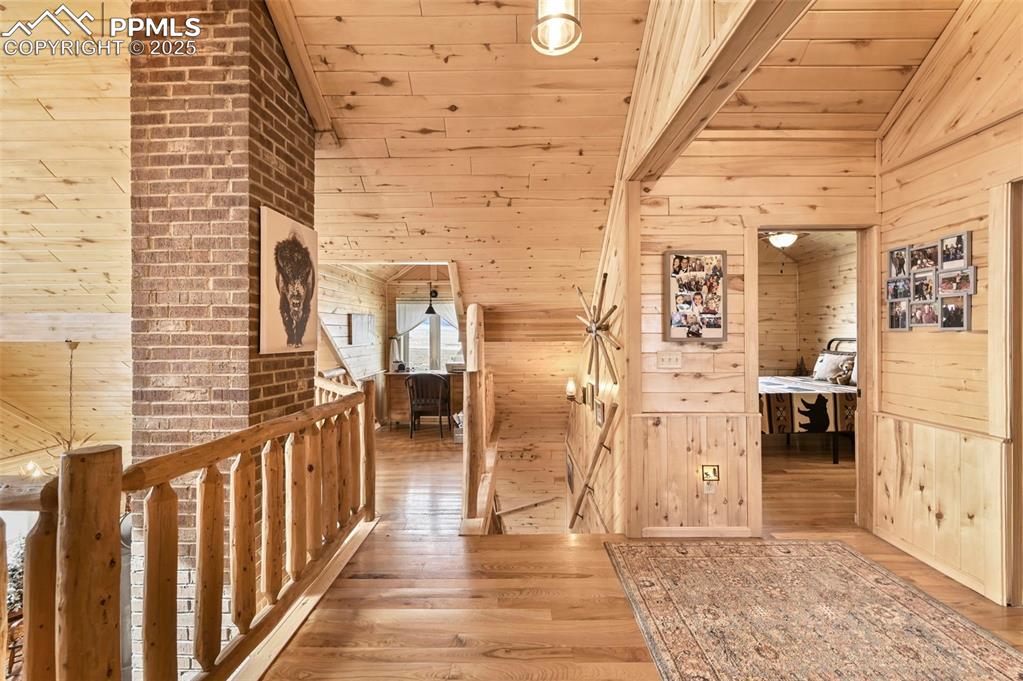 Image 33 of 50: Hallway with wood finished floors, wooden ceiling, lofted ceiling, and wood