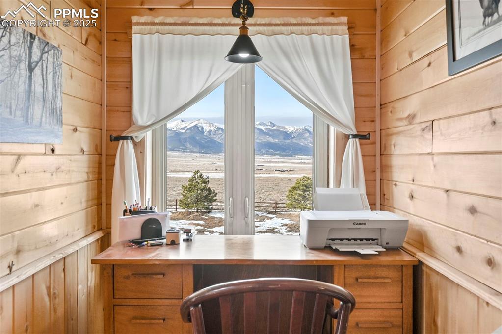 Image 34 of 50: Office featuring built in desk, a mountain view, and wooden walls