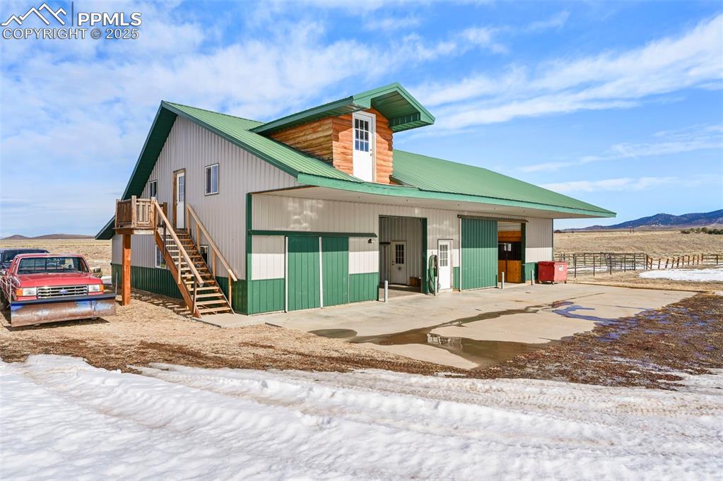 Image 48 of 50: View of front of home featuring stairs, metal roof, a mountain view, and an