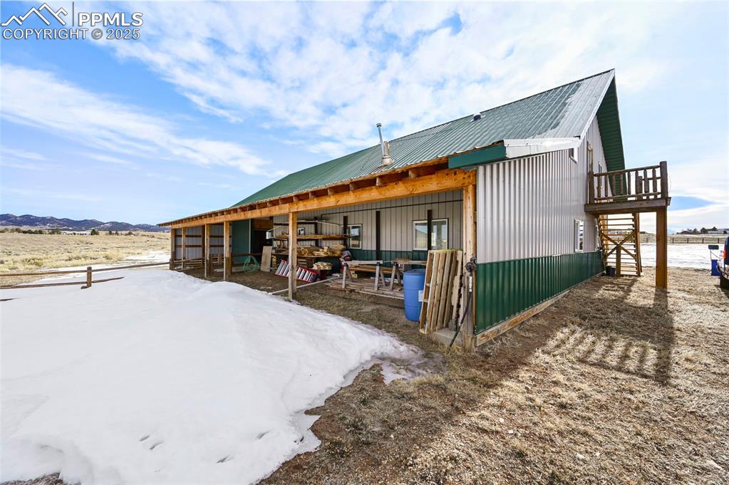 Image 49 of 50: Back of house featuring an outbuilding, an exterior structure, and a mounta