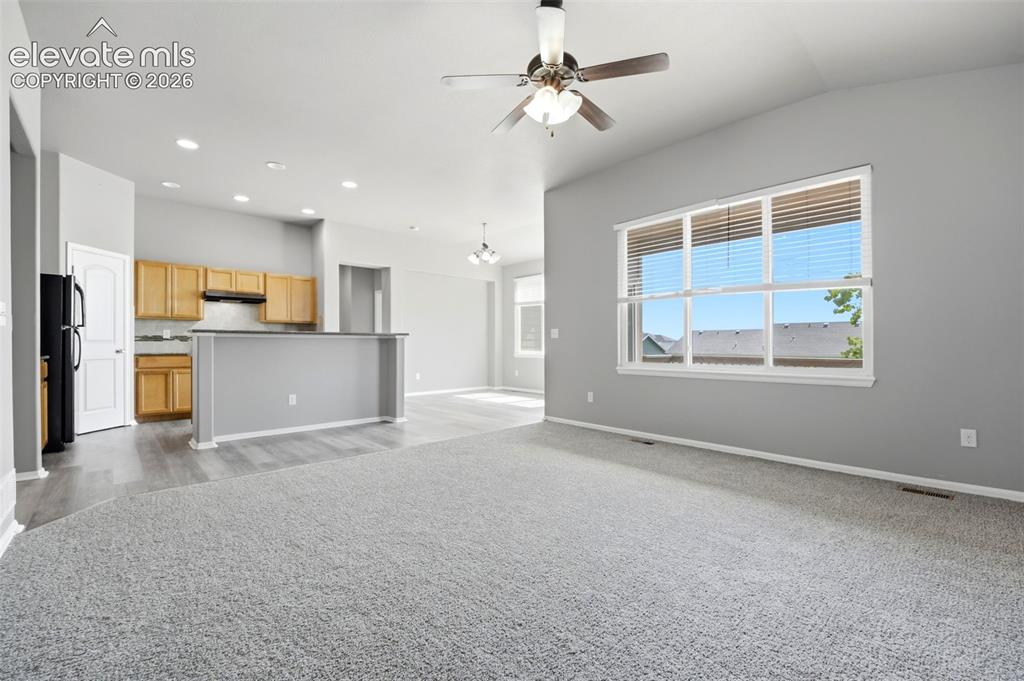 Image 10 of 31: Vaulted ceilings, a ceiling fan with light fixture, large window, wood-fini