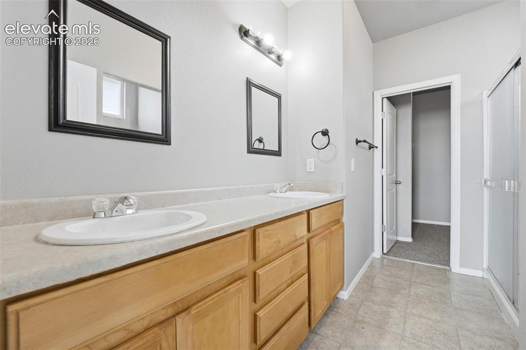 Image 18 of 31: Dual vanity with light-tone wood cabinetry