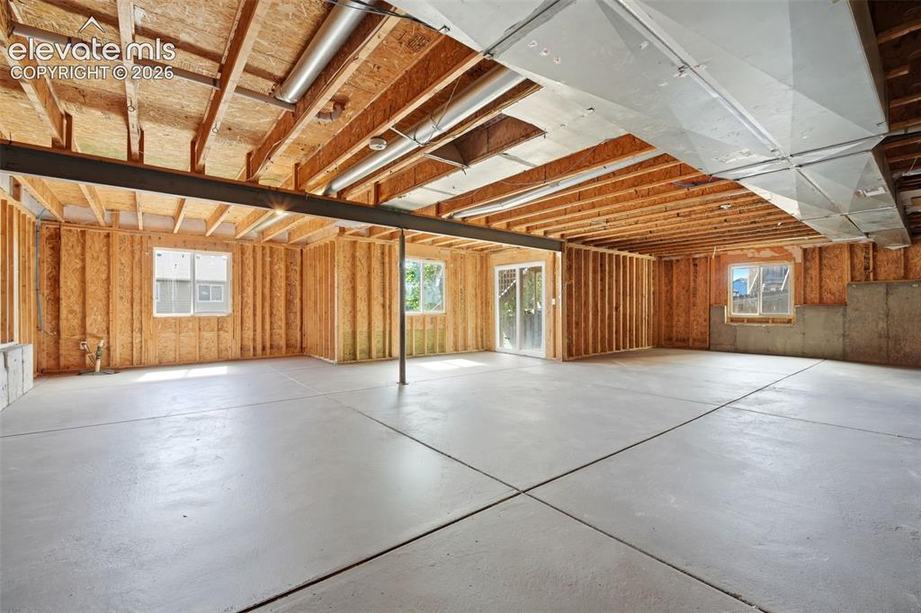 Image 23 of 31: Unfinished basement featuring exposed wood framing, concrete flooring, mult
