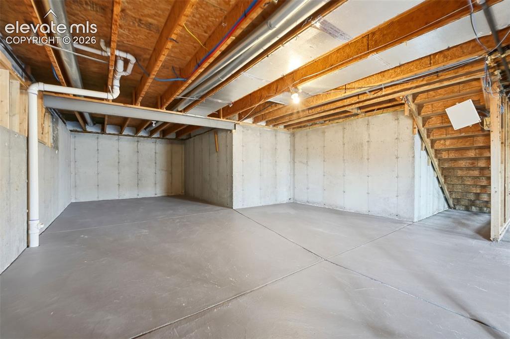 Image 24 of 31: Unfinished basement with concrete flooring and exposed ceiling joists, feat