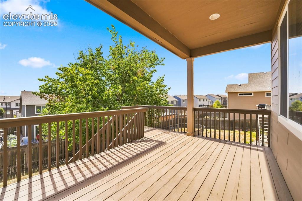 Image 25 of 31: Expansive wood deck with a full railing system, covered patio area, and rec