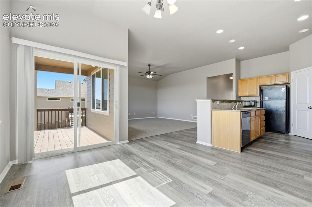 Image 3 of 31: Wood-finish flooring, sliding glass door to outdoor deck, kitchen island wi