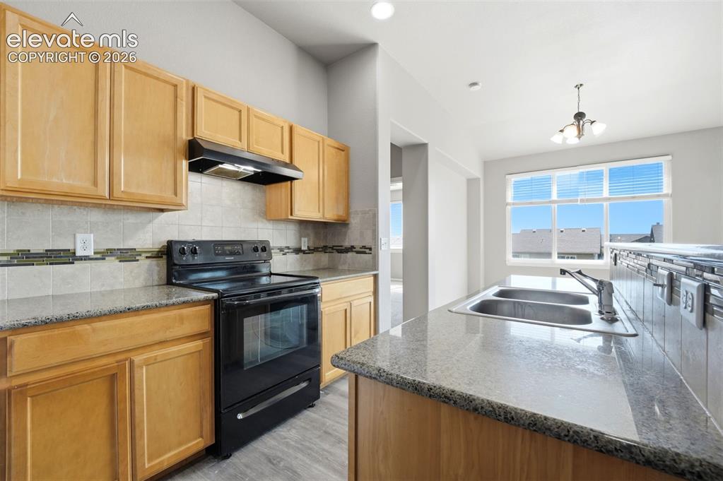 Image 4 of 31: Kitchen featuring light wood cabinetry, stone countertops, stainless steel