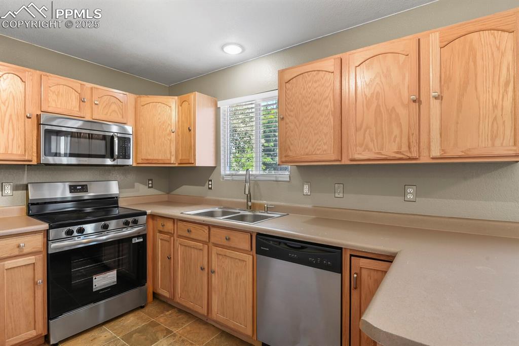 Image 17 of 35: Kitchen featuring stainless steel appliances, light countertops, and light 