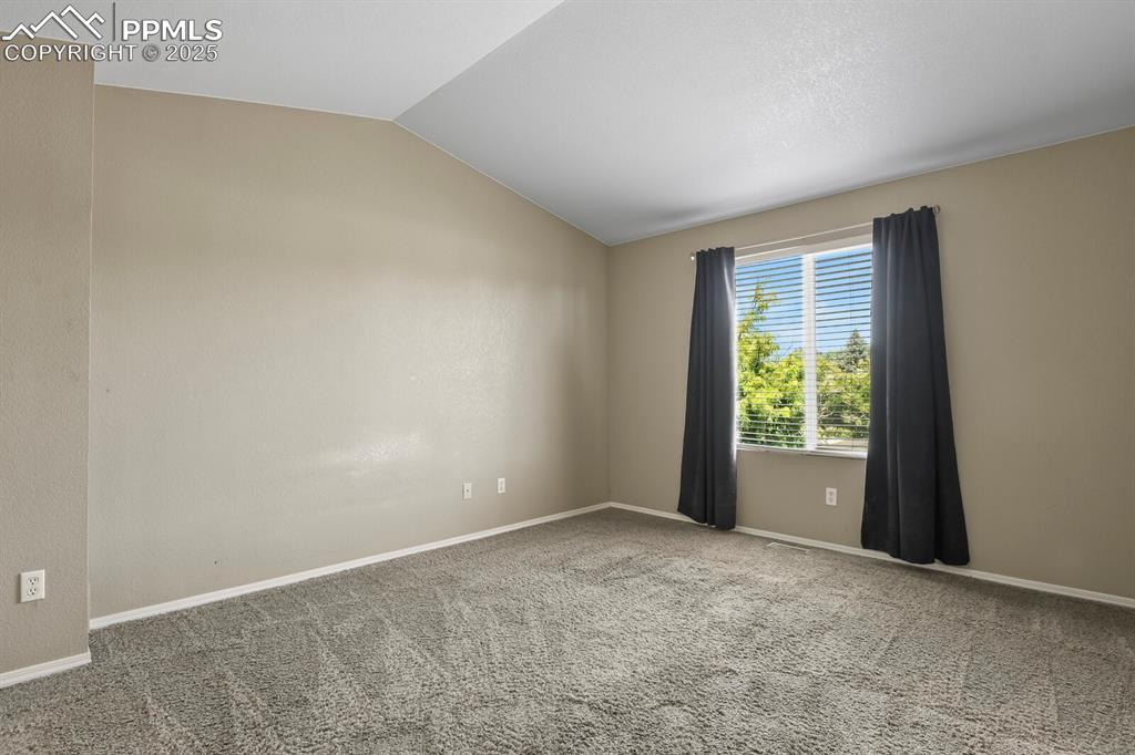 Image 21 of 35: Primary bedroom featuring vaulted ceiling.