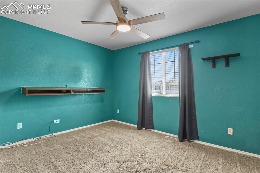 Image 24 of 35: Empty room featuring carpet, ceiling fan, and a textured wall