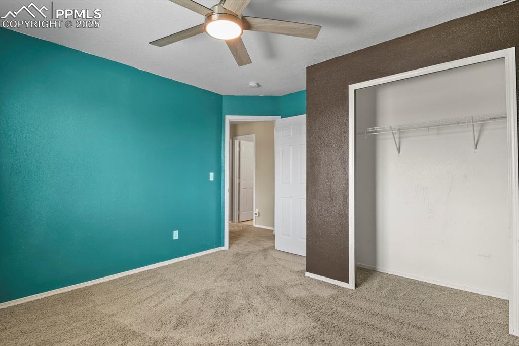 Image 25 of 35: Unfurnished bedroom with carpet floors, ceiling fan, and a closet