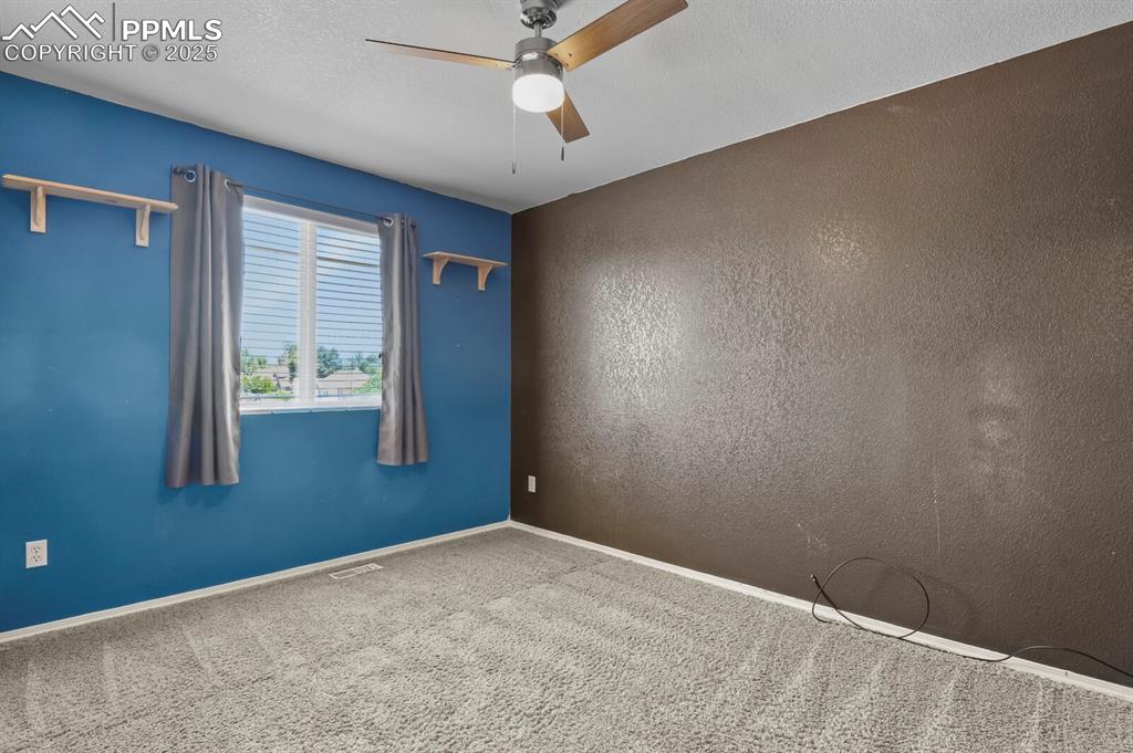 Image 26 of 35: Empty room with a textured ceiling, carpet flooring, and ceiling fan