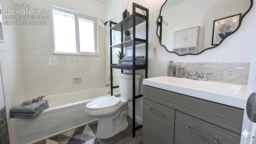 Image 18 of 24: Bathroom featuring a single vanity with a gray wood-finish cabinet and inte