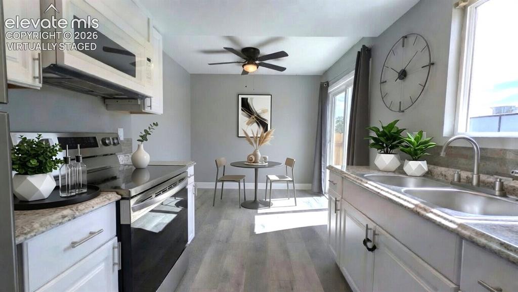 Image 2 of 24: Kitchen featuring light-toned cabinetry with dark hardware, stainless steel