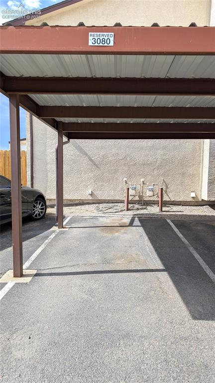 Image 24 of 24: Reserved parking space within a metal-frame carport structure