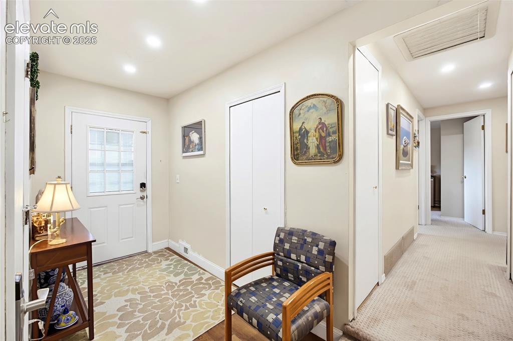 Image 10 of 32: Entryway with a white paneled door featuring a glass insert, recessed light