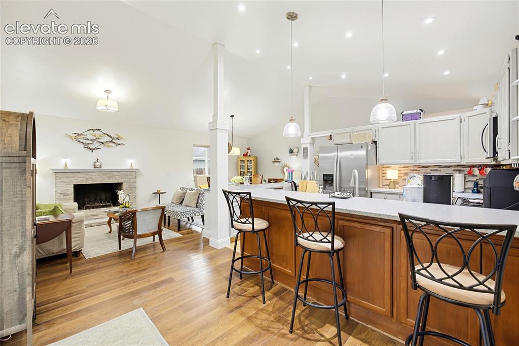 Image 13 of 32: Kitchen island with stone-finish countertop, wood-finish base cabinetry, an