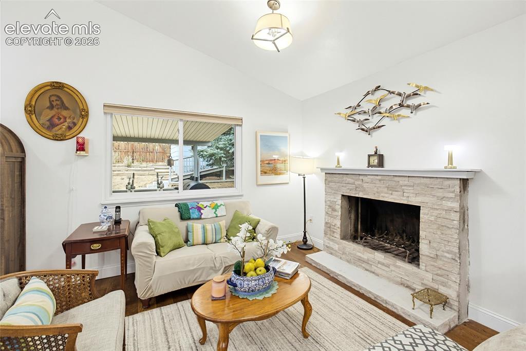 Image 14 of 32: Vaulted ceiling, stone-clad fireplace, wood-finish flooring, built-in firep