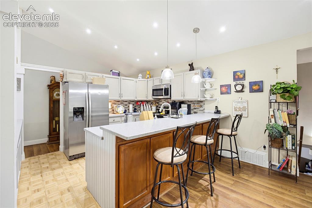 Image 15 of 32: Kitchen featuring white upper cabinetry, a central island with wood-finish 