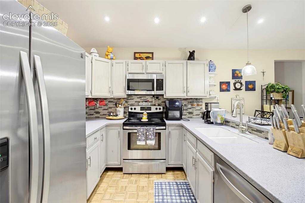 Image 17 of 32: Stainless steel appliances, light-toned cabinetry, light-colored countertop