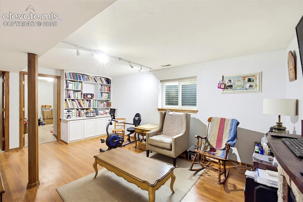 Image 18 of 32: Hardwood-finish flooring, built-in shelving, white cabinetry, track lightin