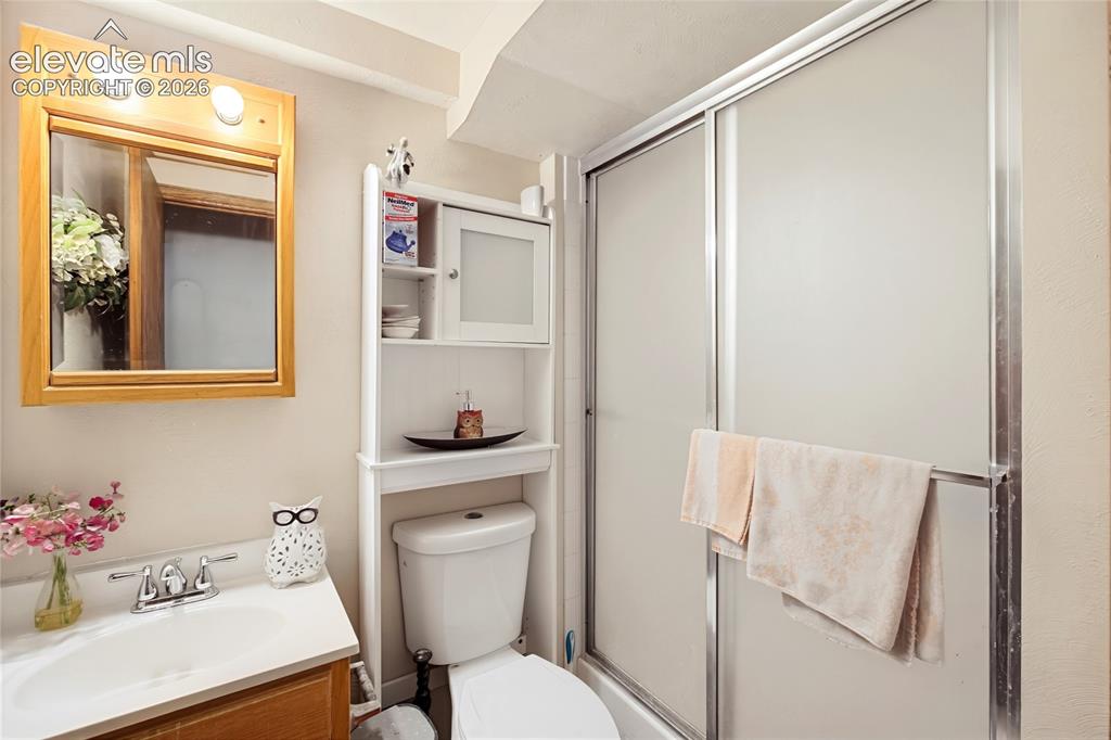 Image 20 of 32: Bathroom featuring a white toilet, built-in storage cabinet, and a shower w