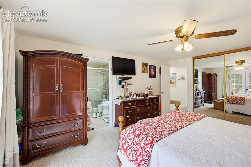 Image 28 of 32: Wall-to-wall carpeting, mirrored closet doors, and an attached ceiling fan