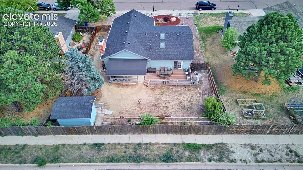 Image 4 of 32: Expansive fenced backyard featuring a multi-level wood deck, covered patio,