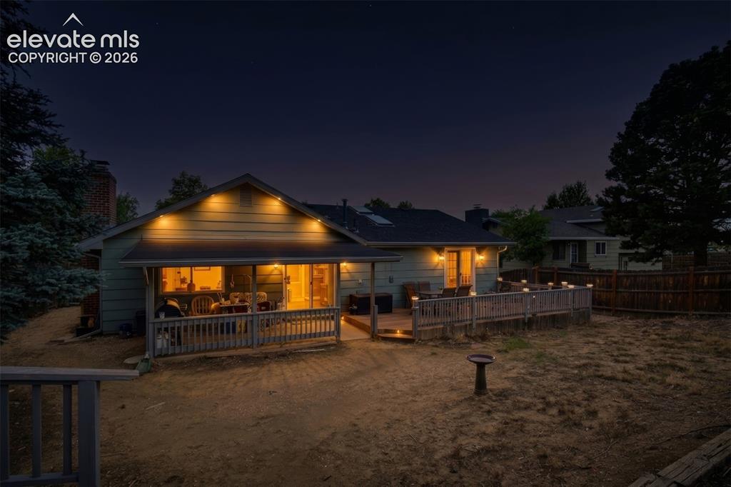 Image 9 of 32: Spacious backyard featuring a covered patio, extensive wooden deck, and mat