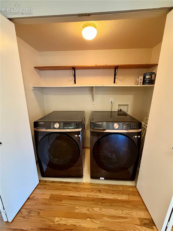 Image 10 of 50: Dedicated laundry area featuring wood-finish flooring, overhead lighting, a