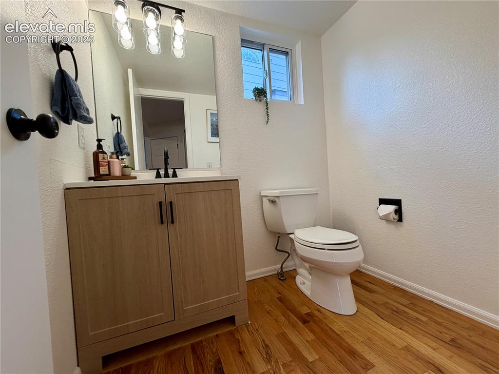 Image 11 of 50: Bathroom with a wood-finish floor and a light wood-finish vanity