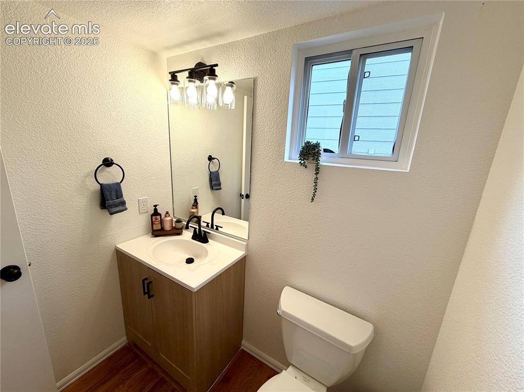 Image 12 of 50: Bathroom featuring a light wood-finish vanity with a white countertop and i