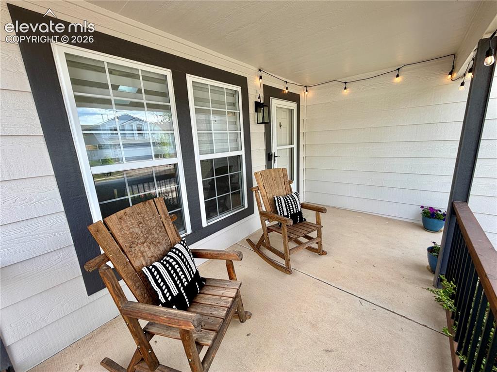 Image 2 of 50: Covered front porch featuring concrete flooring, white siding, and dark tri